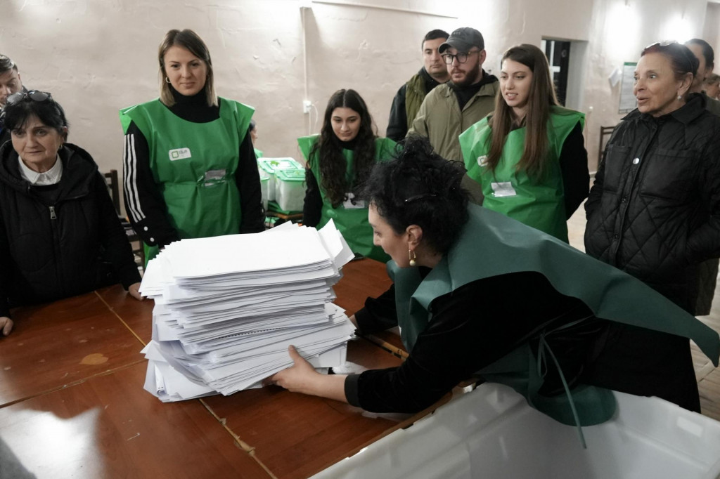 Členovia volebnej komisie sa pripravujú na sčítanie hlasovacích lístkov vo volebnej miestnosti po parlamentných voľbách v gruzínskom Tbilisi. FOTO: TASR/AP