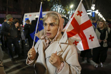 Demonštrantka drží vlajky EÚ a Ukrajiny počas opozičného protestu proti výsledkom parlamentných volieb v gruzínskom Tbilisi v pondelok 28. októbra 2024. FOTO: TASR/AP
