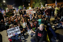 Demonštranti sedia na zemi počas protestu proti izraelskému premiérovi Benjaminovi Netanjahuovi a jeho vláde a za okamžité prepustenie rukojemníkov z Gazy. FOTO: Reuters