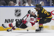 Slovenský hokejista v drese New Jersey Devils Tomáš Tatar a hráč Vancouveru Canucks Erik Brännström bojujú o puk v zápase zámorskej NHL Vancouver Canucks - New Jersey Devils vo Vancouveri. FOTO: TASR/AP