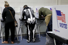 Volič v halloweenskom kostýme hlasuje počas predčasného hlasovania v amerických prezidentských voľbách v americkom meste St. Charles. FOTO: TASR/AP