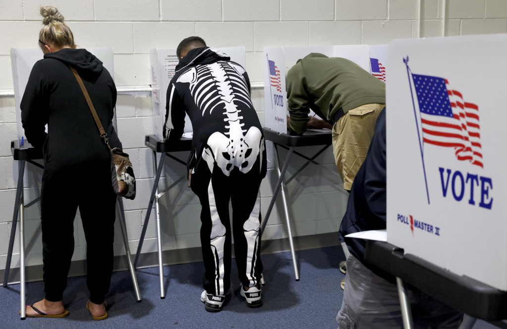 Volič v halloweenskom kostýme hlasuje počas predčasného hlasovania v amerických prezidentských voľbách v americkom meste St. Charles. FOTO: TASR/AP