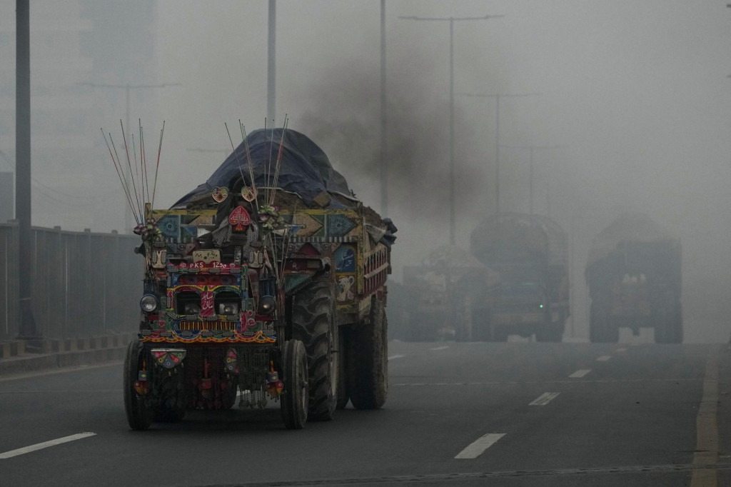 Traktor s vozíkom vypúšťa dym na ceste počas smogu v pakistanskom meste Láhaur. FOTO: TASR/AP