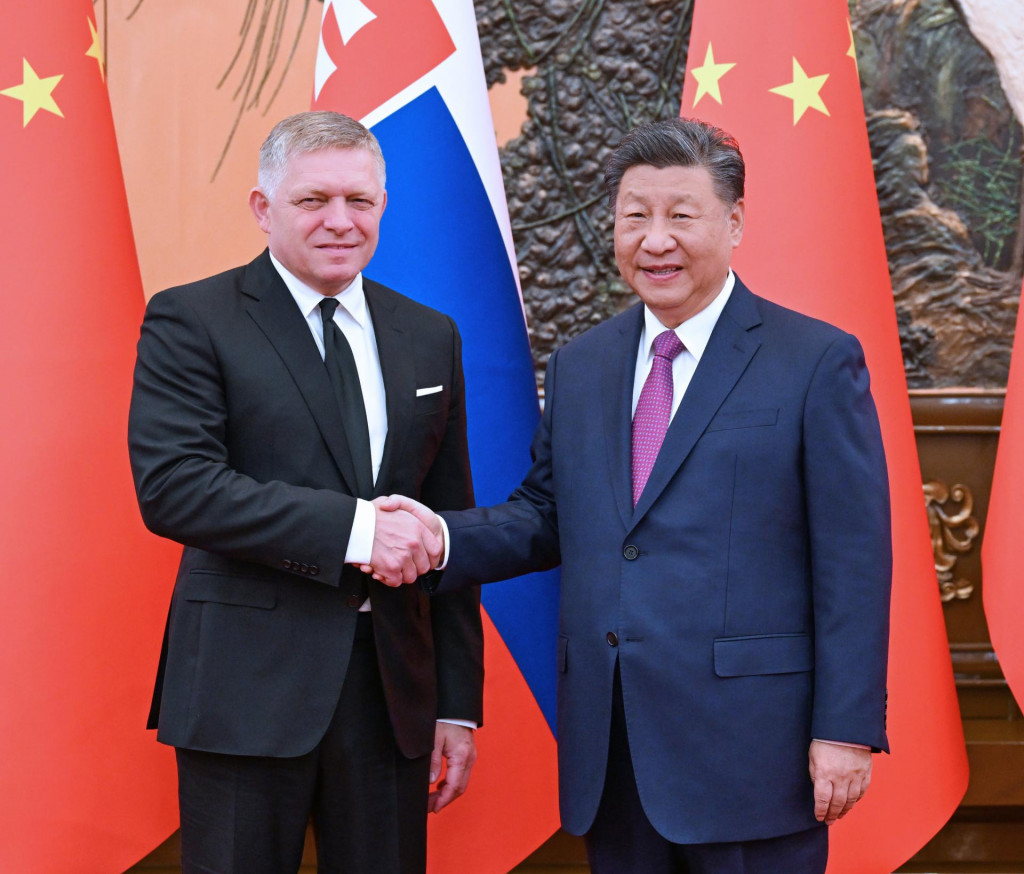 Slovenský premiér Robert Fico (vľavo) a čínsky prezident Si Ťin-pching si podávajú ruky počas stretnutia v Pekingu. FOTO: TASR/XINHUA