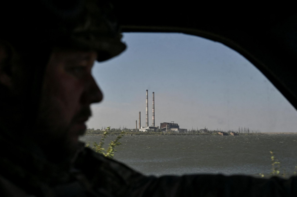 Policajt vedie vozidlo popri Kurachovskej tepelnej elektrárni počas evakuácie civilistov z okraja mesta Kurachove v Doneckej oblasti na Ukrajine. FOTO: REUTERS