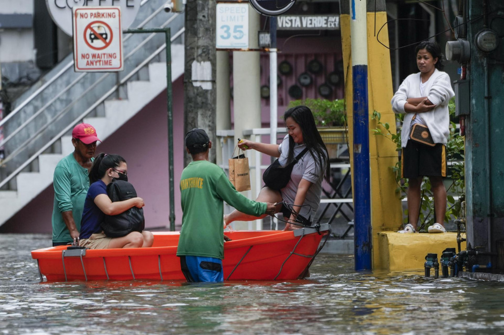 Obyvatelia používajú čln na zaplavenej ulici po záplavách spôsobených tropickou búrkou Trami v meste Cainta na Filipínach 25. októbra 2024. FOTO: TASR/AP