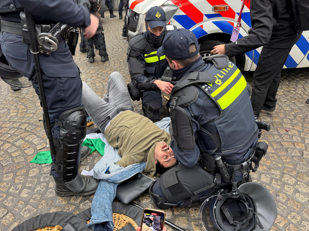 Holandská polícia pomáha propalestínskemu demonštrantovi počas zakázanej demonštrácie v Amsterdame. FOTO: REUTERS