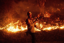 Hasič zasahuje pri požiari v kalifornskom meste Santa Paula. FOTO: TASR/AP