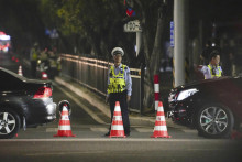 Pracovníci bezpečnostných zložiek hliadkujú neďaleko športového centra, do ktorého narazilo auto v juhočínskom meste Ču-chaj. FOTO: TASR/AP