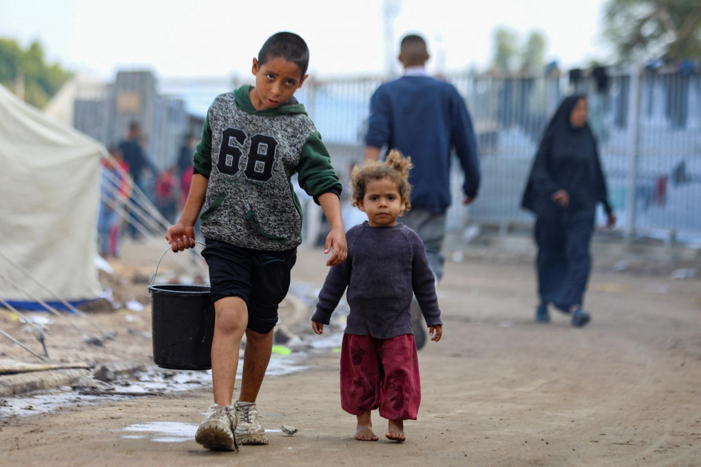 Deti sa prechádzajú v stanovom tábore zriadenom na poškodenom futbalovom štadióne v meste Gaza. FOTO: Reuters