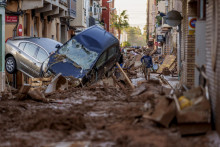 Na snímke muž kráča po ulici po záplavách vo Valencii 2. novembra 2024.