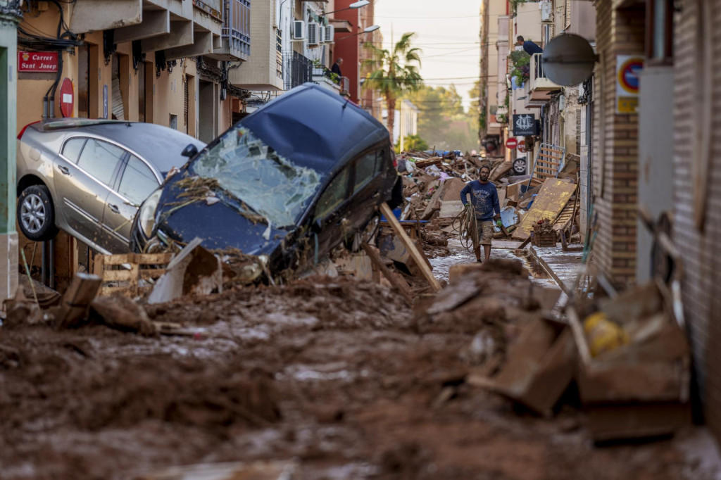 Na snímke muž kráča po ulici po záplavách vo Valencii 2. novembra 2024.