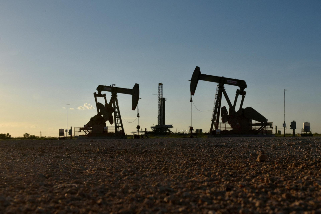 FILE PHOTO: Pump jacks operate in front of a drilling rig in an oil field in Midland, Texas U.S. August 22, 2018. Picture taken August 22, 2018. REUTERS/Nick Oxford/File Photo FOTO: Nick Oxford