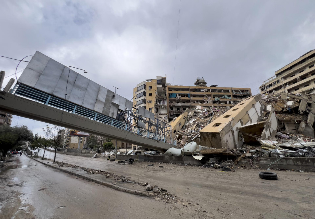 Z jednej strany zrútený most pre chodcov vedľa zničenej obytnej budovy po izraelskom leteckom útoku na štvrť Dahíja, na južnom predmestí Bejrútu. FOTO: TASR/AP