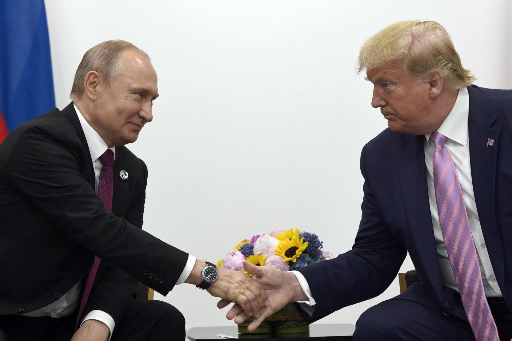 Na archívnej snímke z 28. júna 2019 americký prezident Donald Trump (vpravo) a ruský prezident Vladimir Putin si podávajú ruky počas bilaterálneho stretnutia v rámci samitu G20 v Osake. FOTO: TASR/AP