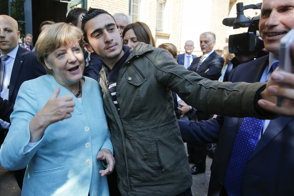 Bývalá nemecká kancelárka Angela Merkelová si robí selfie s utečencom počas vrcholu migračnej krízy v Nemecku. FOTO: REUTERS