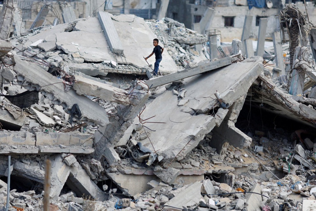 Palestínsky chlapec stojí na troskách domu zničeného pri izraelskej vojenskej ofenzíve. FOTO: Reuters