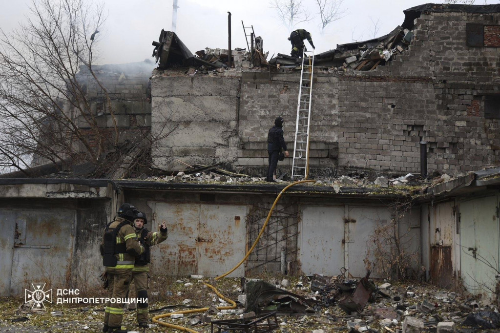 Príslušníci záchranných zložiek hasia požiar budovy, ktorú silne poškodil letecký útok ruskej armády na ukrajinské mesto Dnipro. FOTO: TASR/AP