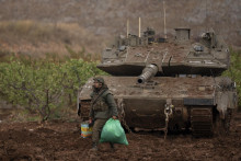 Izraelský vojak kráča okolo tanku neďaleko izraelsko-libanonských hraníc. FOTO: TASR/AP