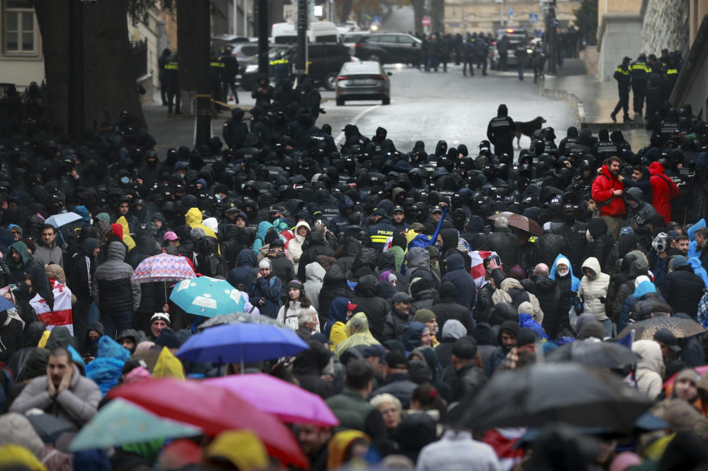 Polícia blokuje demonštrantov zhromaždených na ulici, ktorí požadujú nové parlamentné voľby v Gruzínsku, neďaleko budovy parlamentu v Tbilisi. FOTO: TASR/AP