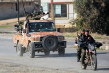 Povstalci vedení islamistickou militantnou skupinou Hayat Tahrir al-Sham jazdia na motorke v al-Rashideen v provincii Aleppo v Sýrii. FOTO: Reuters