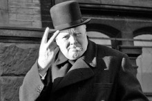 Bývalý britský premiér Winston Churchill (1874 – 1965) ukazuje svoje typické víťazné gesto.