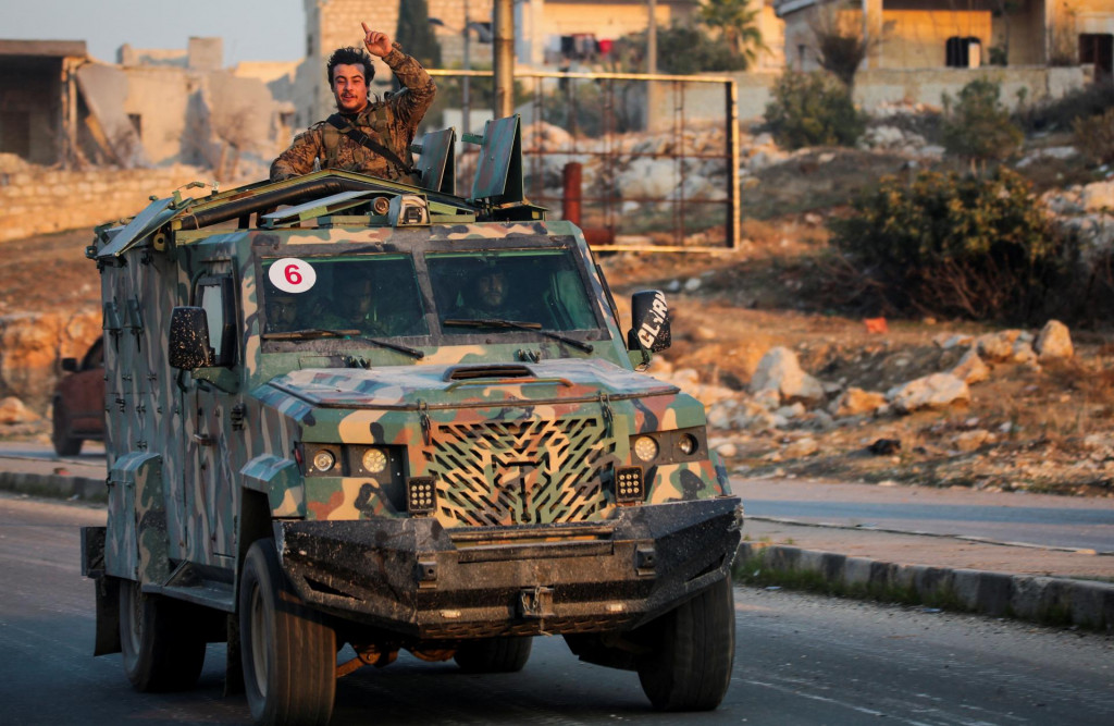 Rebel pod vedením islamistickej militantnej skupiny Hayat Tahrir al-Sham stojí v zadnej časti vozidla v al-Rashideen v provincii Aleppo v Sýrii. FOTO: Reuters