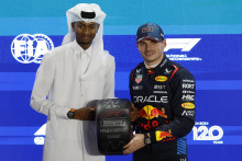 Max Verstappen pózuje s trofejou po umiestnení na pole position v kvalifikácii s katarským olympijským výškarom Mutazom Barshamom. FOTO: Reuters