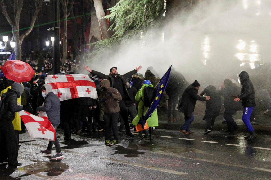 Policajti používajú vodné delo na rozohnanie davu počas zhromaždenia priaznivcov opozičných strán, ktorí protestujú proti rozhodnutiu novej vlády pozastaviť prístupové rozhovory do Európskej únie. FOTO: Reuters