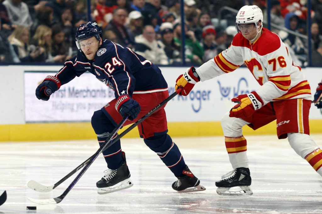 Slovenský útočník Martin Pospíšil (vpravo) z Calgary Flames a útočník Mathieu Olivier z Columbusu Blue Jackets počas zápasu zámorskej NHL Columbus Blue Jackets - Calgary Flames 29. novembra 2024 v Columbuse. FOTO TASR/AP