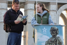 Muž číta leták od členky kampane propagujúcej službu v ruskej armáde v Moskve. FOTO: Reuters