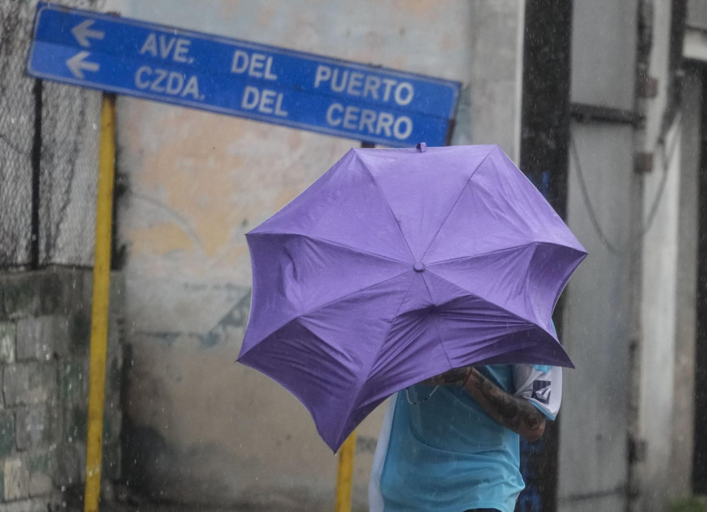 Muž počas hurikánu Rafael v meste Havana. Hurikán tretej kategórie sprevádzaný vetrom dosahujúcim v nárazoch rýchlosť 185 kilometrov za hodinu zasiahol západ Kuby. FOTO: TASR/AP