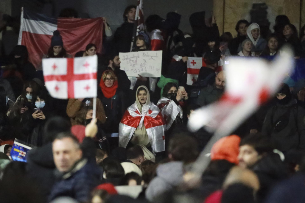 Demonštranti s gruzínskymi vlajkami stoja počas protestu pred budovou parlamentu v gruzínskej metropole Tbilisi. FOTO: TASR/AP