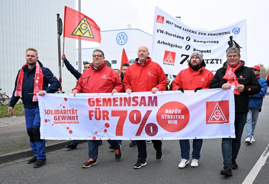 Zamestnanci Volkswagen AG pochodujú za vyššie mzdy pred závodom Volkswagen v Osnabrücku. Na plagáte je napísané: „Solidarita víťazí. Spoločne za zvýšenie platov o 7 percent – ​​to je to, za čo bojujeme.” FOTO: Reuters