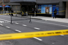 Policajti stoja blízko miesta, kde bol zastrelený generálny riaditeľ UnitedHealthcare Brian Thompson v Midtown Manhattan, v New York City, USA.