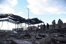 Libanonský vojenský personál a ľudia kontrolujú škody na libanonsko-sýrskom hraničnom priechode Arida po tom, čo bol poškodený po izraelskom údere. FOTO: Reuters