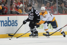 Slovenský hokejista v drese New Jersey Devils Tomáš Tatar (vľavo) a hráč Nashville Predators Tommy Novak bojujú o puk počas zápasu zámorskej NHL New Jersey Devils - Nashville Predators v Newarku. FOTO: TASR/AP