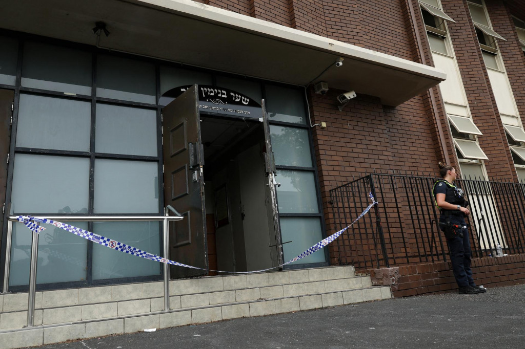 Policajtka stojí na stráži na mieste požiaru synagógy v austrálskom Melbourne. FOTO: Reuters/AAP