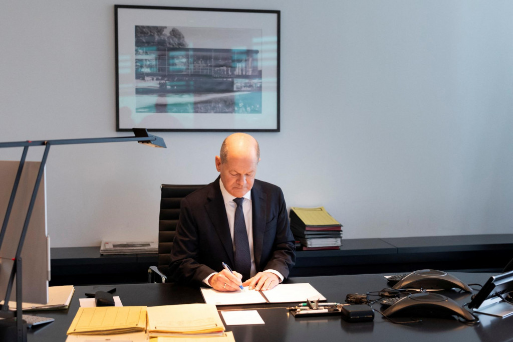 Nemecký kancelár Olaf Scholz podpisuje v Berlíne žiadosť o vyslovenie dôvery. FOTO: REUTERS