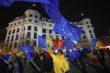 Ľudia mávajú vlajkami Rumunska a Európskej únie na proeurópskom zhromaždení pred druhým kolom prezidentských volieb v Bukurešti. FOTO: TASR/AP