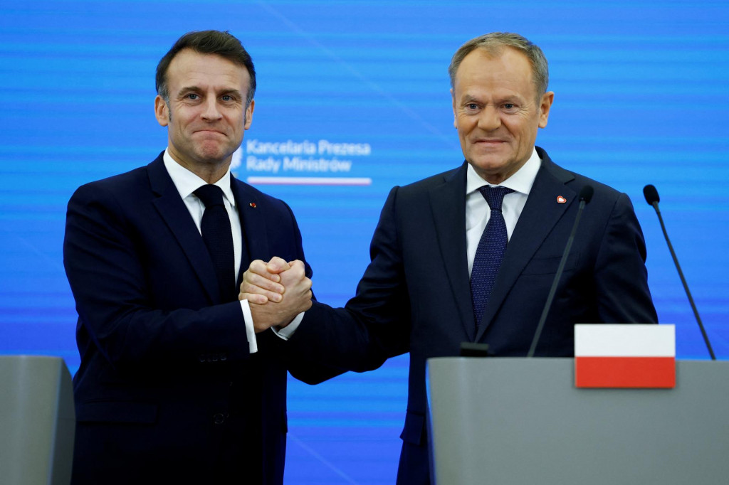 Poľský premiér Donald Tusk si podáva ruku s francúzskym prezidentom Emmanuelom Macronom v kancelárii predsedu vlády vo Varšave. FOTO: Reuters