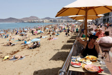 Turisti jedia na terase vedľa pláže Las Canteras v Las Palmas de Gran Canaria. FOTO: Reuters