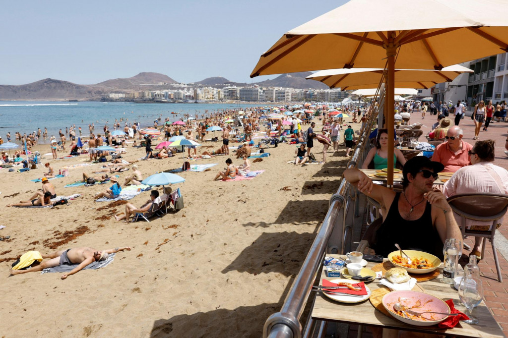 Turisti jedia na terase vedľa pláže Las Canteras v Las Palmas de Gran Canaria. FOTO: Reuters