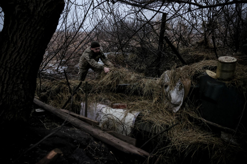 Ukrajinský vojak maskuje samohybnú húfnicu neďaleko mesta Časiv Jar v Doneckej oblasti. FOTO: Reuters/Ukrajinské ozbrojené sily