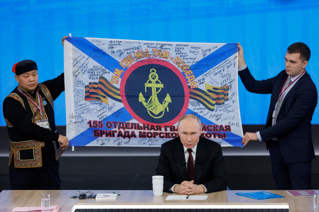 Vlajka 155. samostatnej gardovej brig&aacute;dy ruskej n&aacute;mornej pechoty vis&iacute; za rusk&yacute;m prezidentom Vladimirom Putinom počas jeho v&yacute;ročnej koncoročnej tlačovej konferencie. FOTO: Reuters
