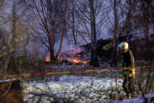 Záchranár prechádza popri troskách nákladného lietadla DHL na mieste havárie neďaleko medzinárodného letiska Vilnius. FOTO: Reuters