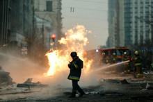 Hasiči pracujú na hasení požiaru v blízkosti miesta budovy zničenej počas ruského raketového útoku v centre Kyjeva. FOTO: Reuters