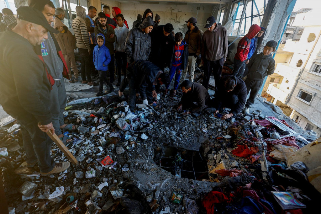 Palestínčania kontrolujú škody po izraelskom údere na školu ukrývajúcu vysídlené osoby uprostred konfliktu medzi Izraelom a Hamasom v Chán Júnise. FOTO: Reuters