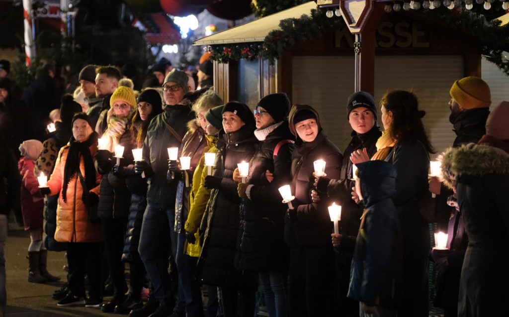 Stovky ľudí vytvárajú živú reťaz na pamiatku obetí piatkového útoku autom na vianočné trhy v nemeckom meste Magdeburg. FOTO: TASR/AP