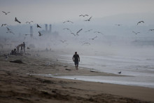 Muž kráča po Manhattan Beach v Los Angeles v Kalifornii. FOTO: Reuters